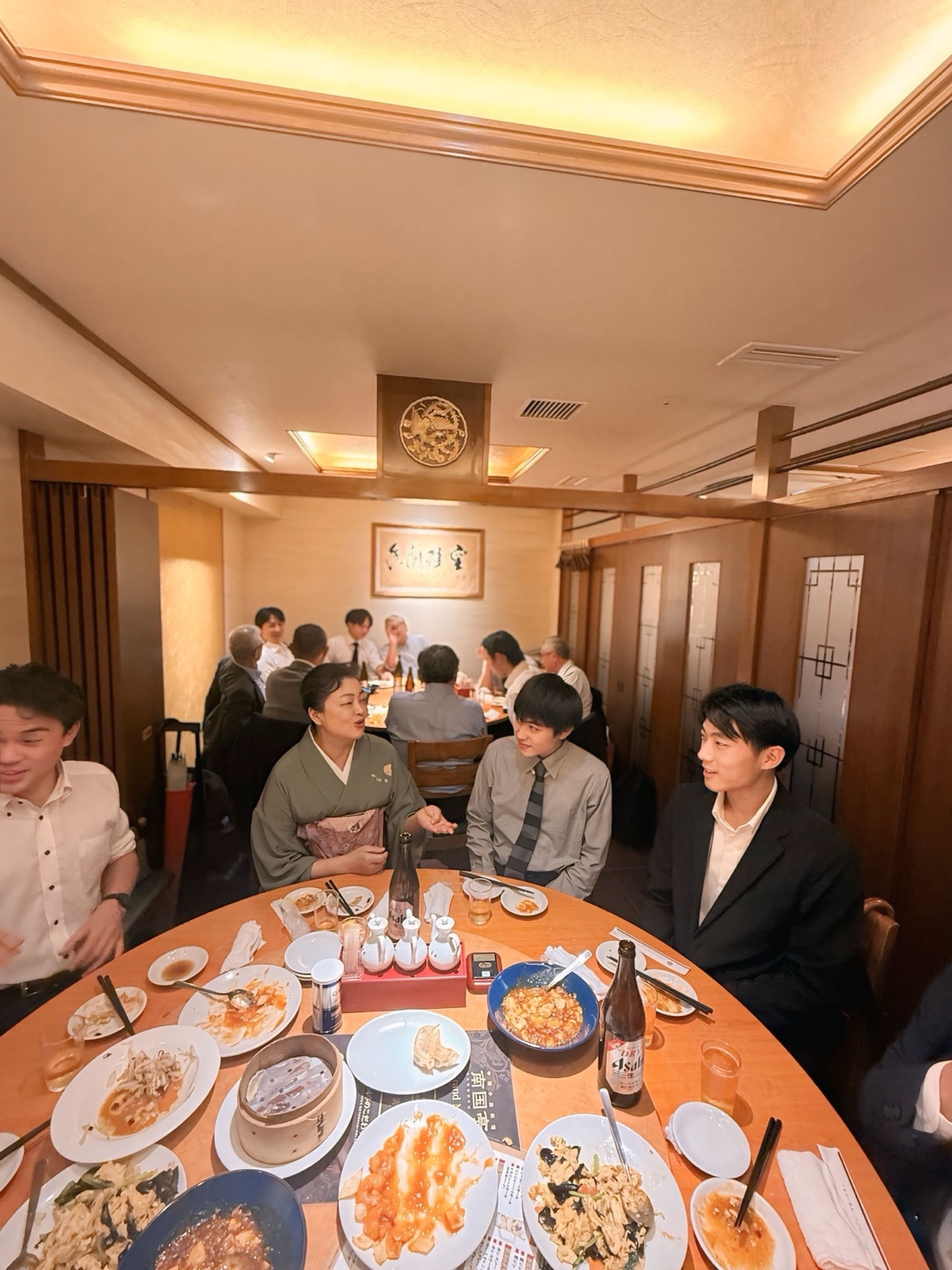 中華料理を囲む円卓で、参加者同士の会話が続きます。