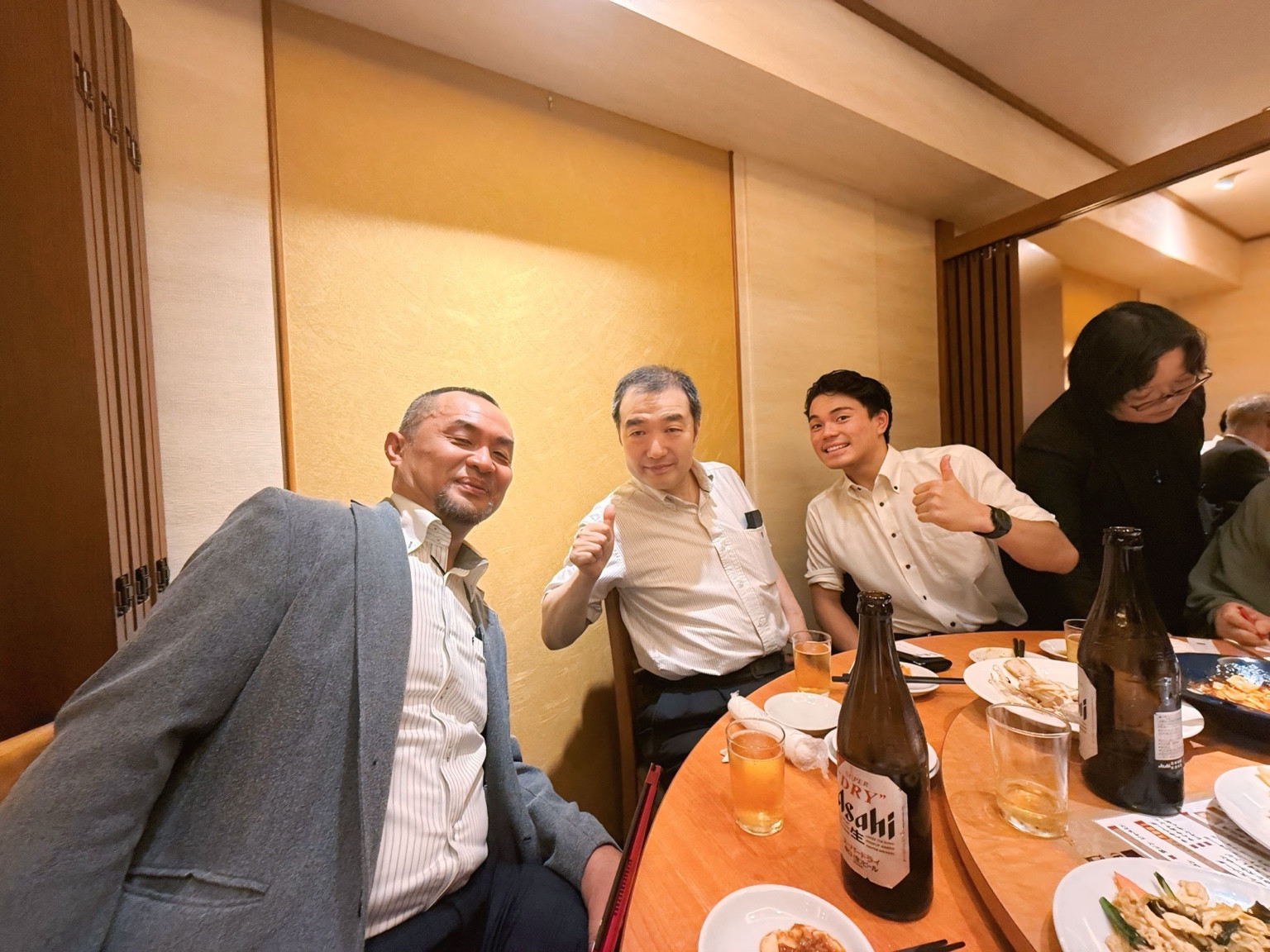 食事の席でカメラに笑顔を向ける皆さん。