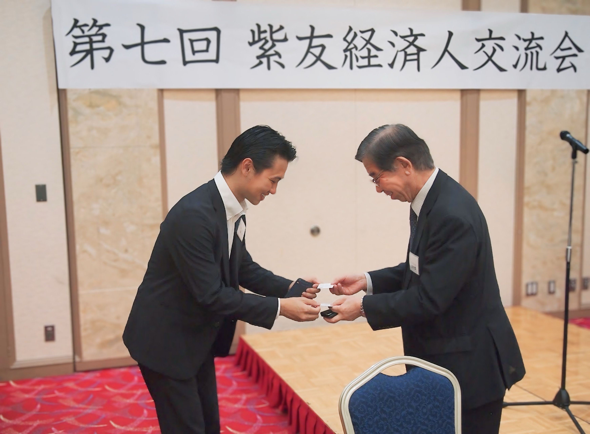 名刺を交換しながら笑顔で挨拶。