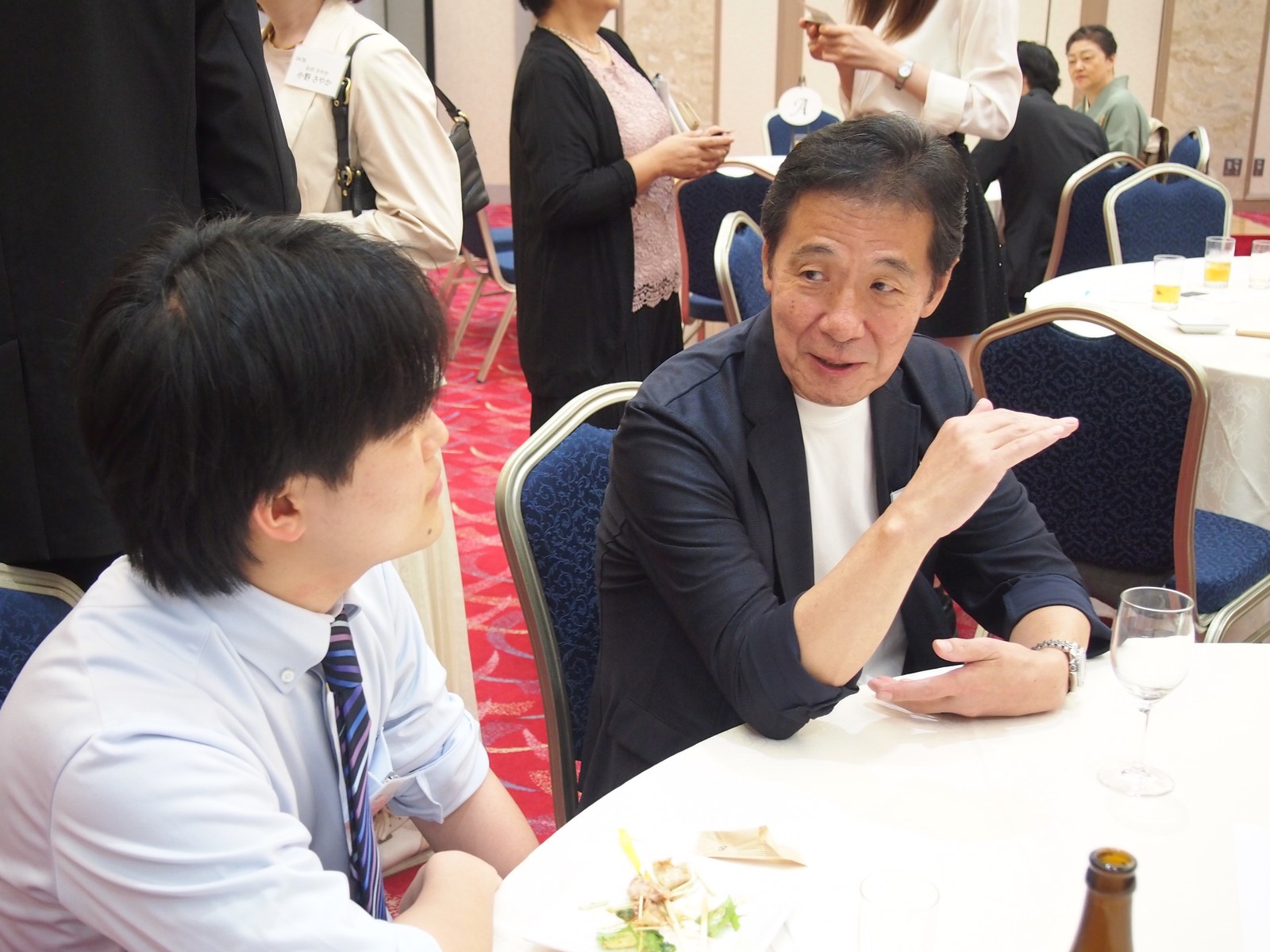 第7回交流会で食事のテーブルを囲んで話す参加者